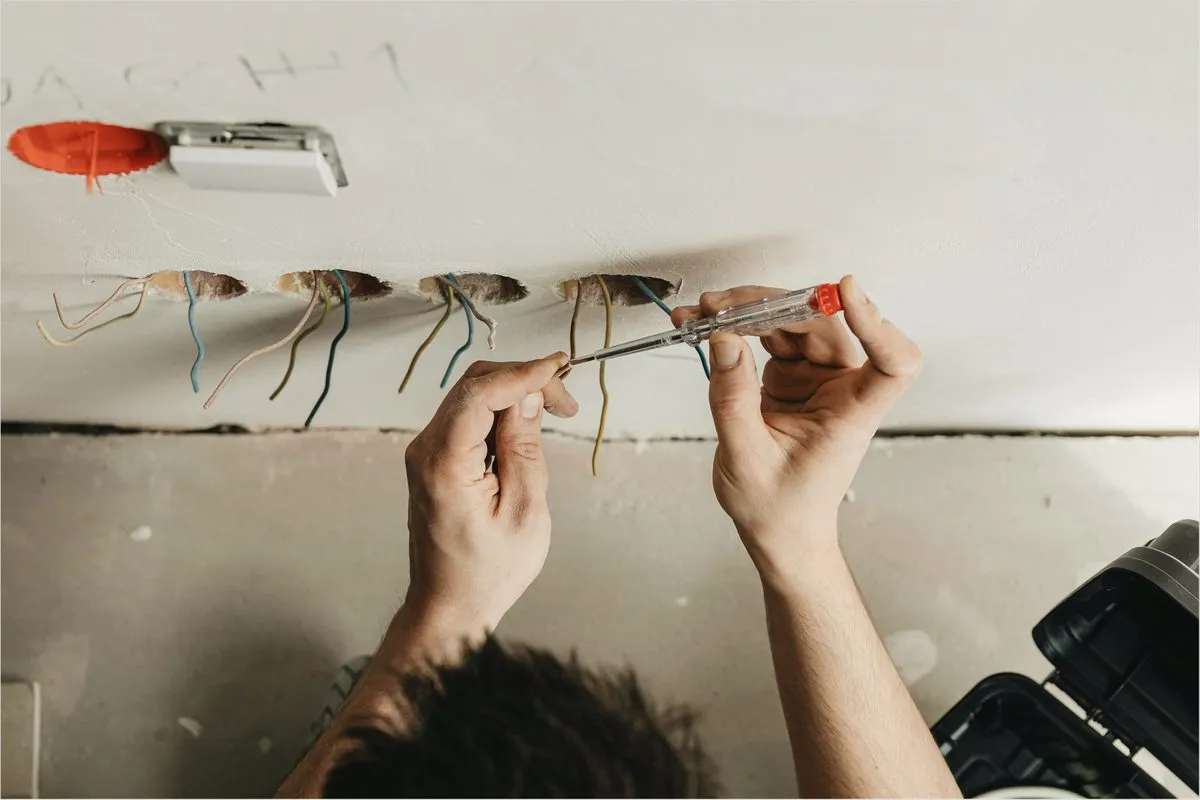 An electrician joining wires at a ceiling box