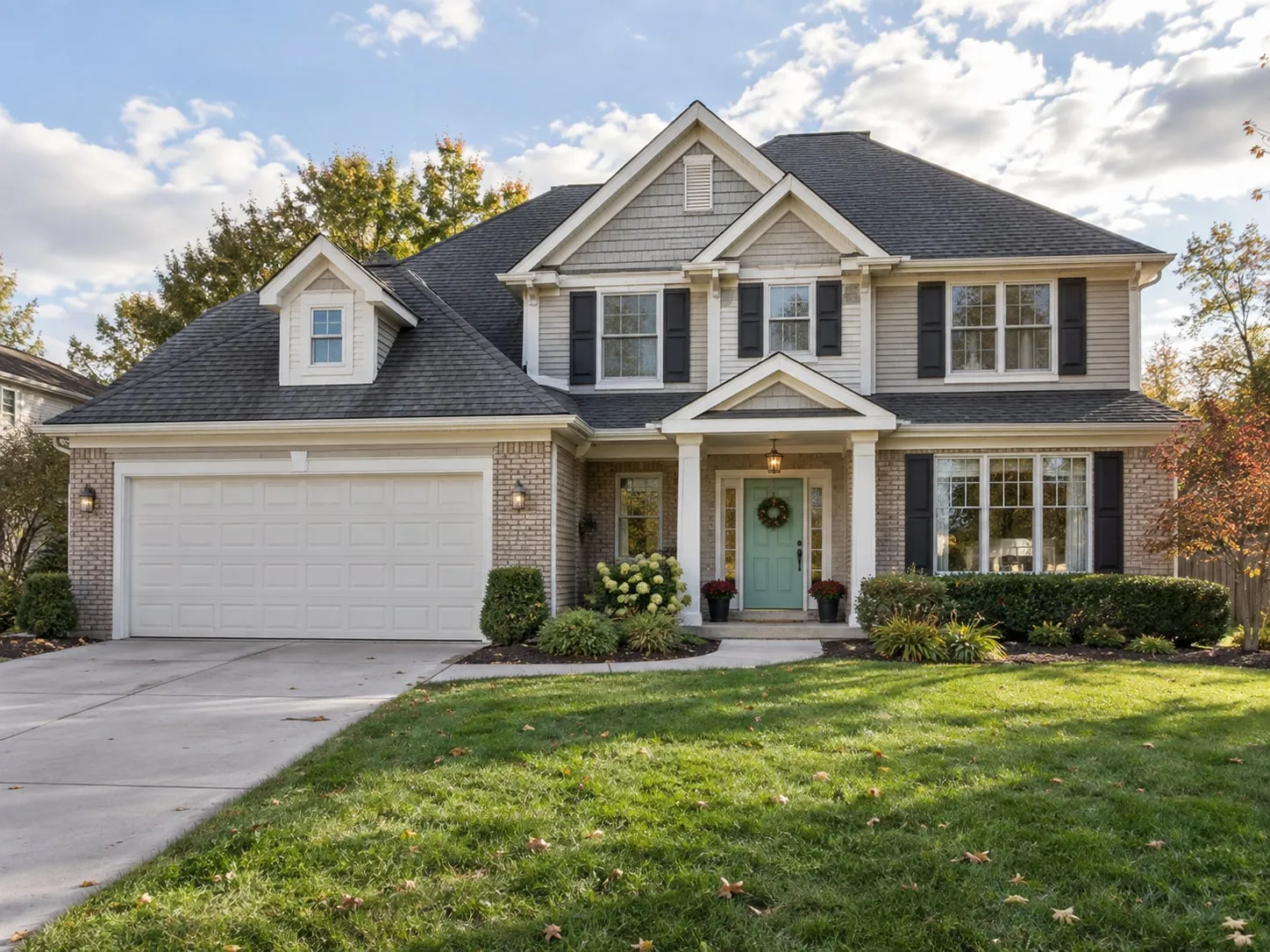 Two-story suburban home with a two-car garage and a landscaped front lawn